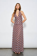 Woman wearing a brown dress with white polka dots against a white background