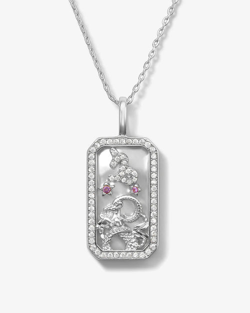 Silver pendant with intricate designs and gemstones on a white background