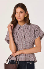 Woman wearing a checkered blouse with a plain background