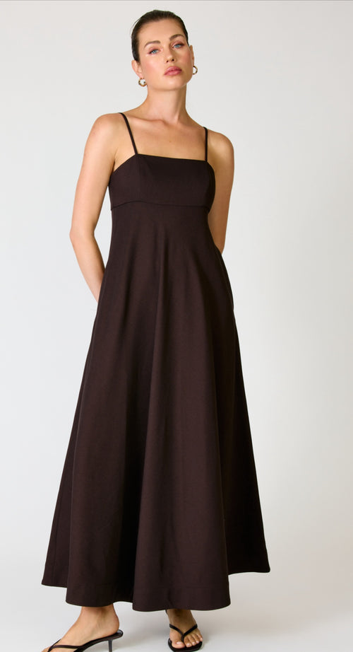 Woman wearing a black dress against a white background