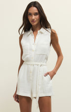 Woman wearing a white sleeveless shirt dress against a plain background