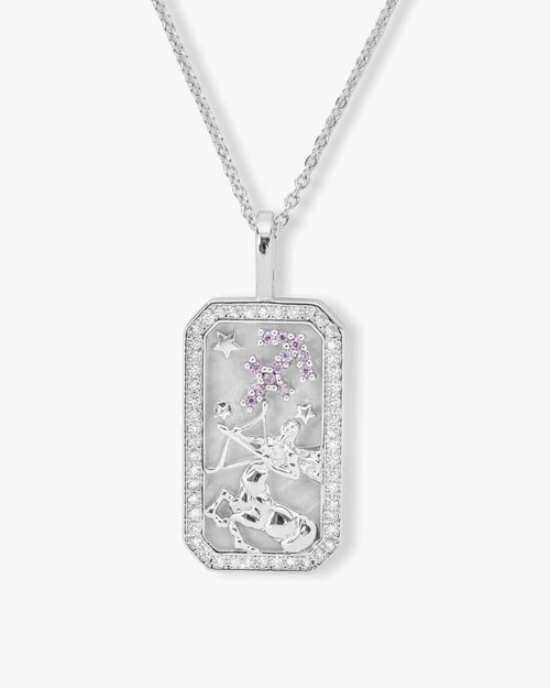 Silver pendant with star and moon designs on a white background