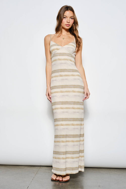 Woman wearing a long, striped dress against a white background