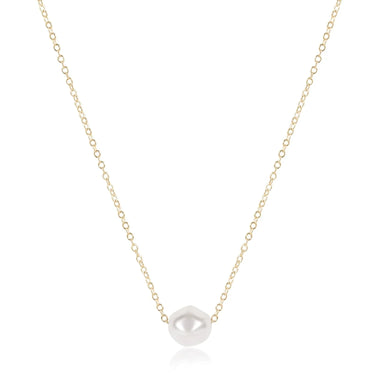 Gold necklace with a single pearl pendant on a white background