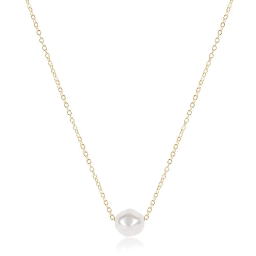 Gold necklace with a single pearl pendant on a white background