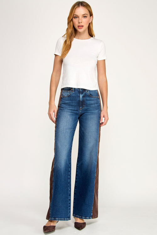 Woman wearing blue flared jeans and a white t-shirt on a white background