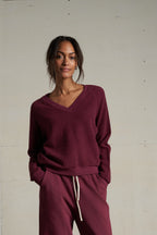 Woman wearing a burgundy outfit against a plain background