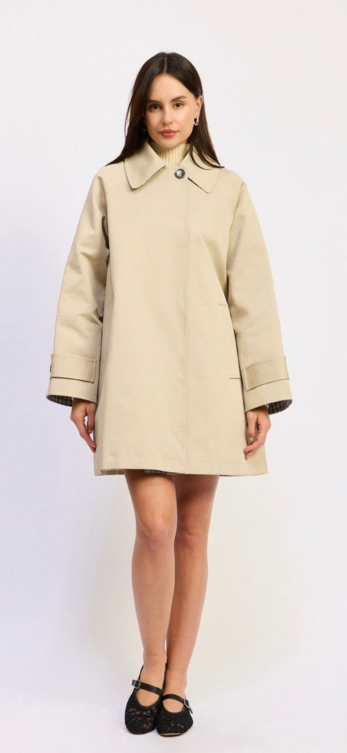 Woman wearing a beige coat on a white background