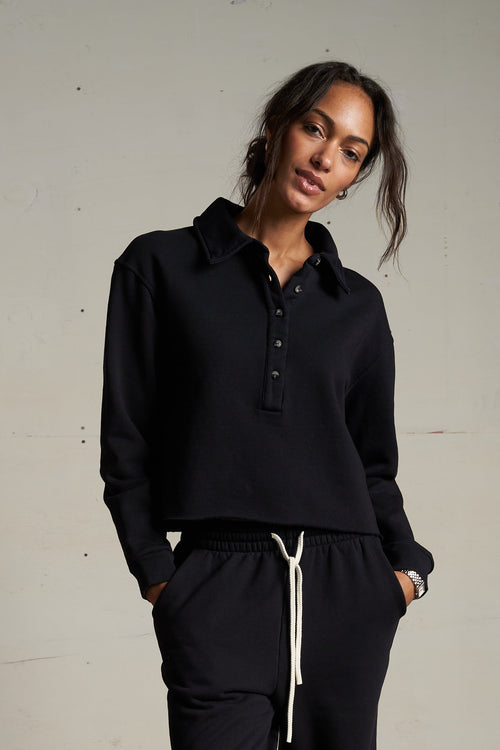 Woman wearing a black outfit with a plain background