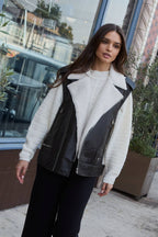 Woman wearing a white jacket with black accents in an urban setting