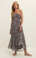 Woman wearing a leaf-patterned dress on a plain background