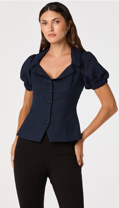 Woman wearing a navy blue blazer with puff sleeves on a white background