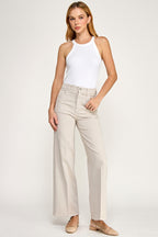 Woman wearing a white halter top and beige pants on a white background