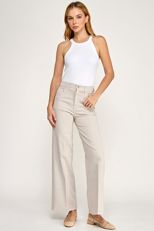 Woman wearing a white halter top and beige pants on a white background