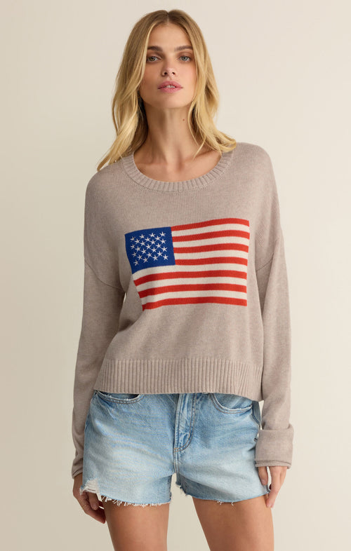 Woman wearing a sweater with an American flag design on a beige background