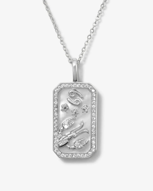 Silver pendant necklace with intricate designs on a white background