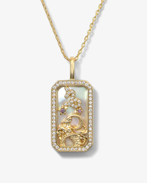 Gold pendant necklace with intricate design on a white background