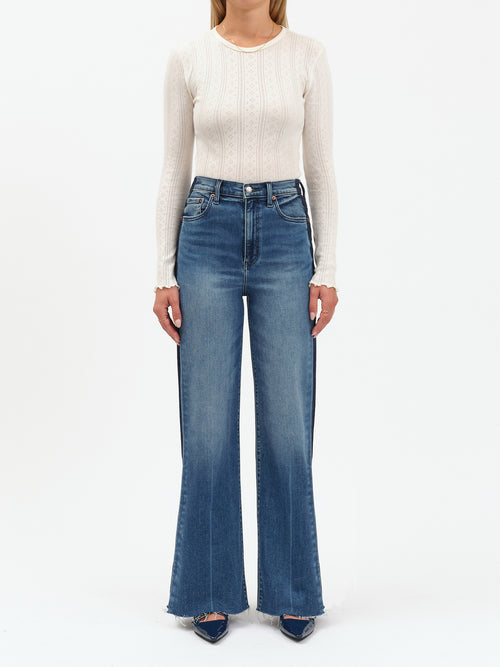 Person wearing a white sweater and blue jeans on a white background