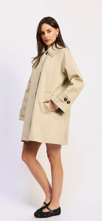 Woman wearing a beige coat on a white background