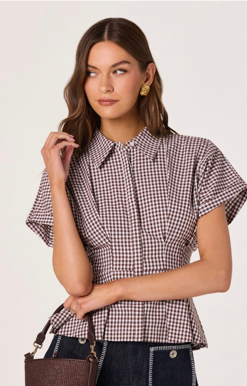 Woman wearing a checkered blouse with a plain background