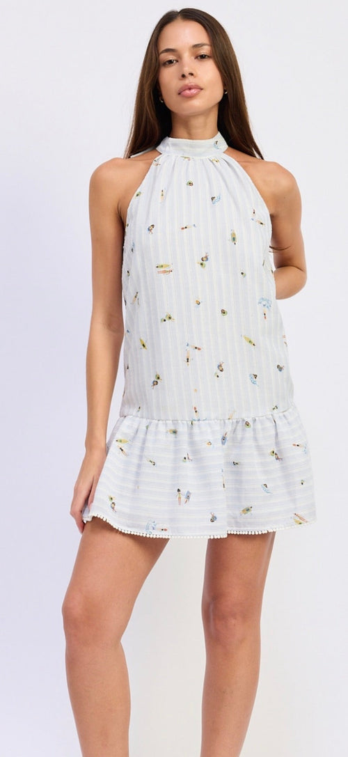 Woman wearing a white halter neck dress with floral pattern on a light purple background