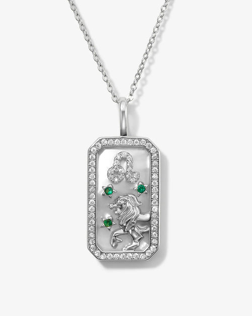 Silver pendant with green gemstones and a lion design on a white background