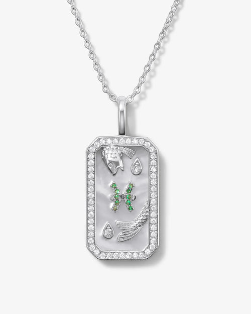 Silver pendant with green gemstones on a white background