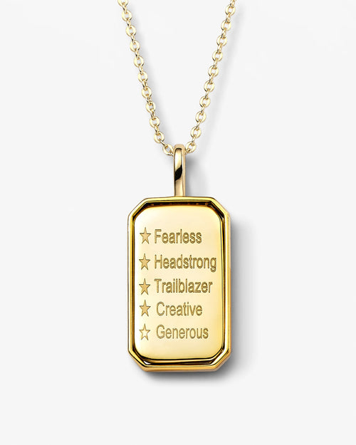 Gold pendant necklace with engraved words on a white background
