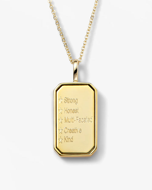 Gold pendant necklace with engraved text on a white background